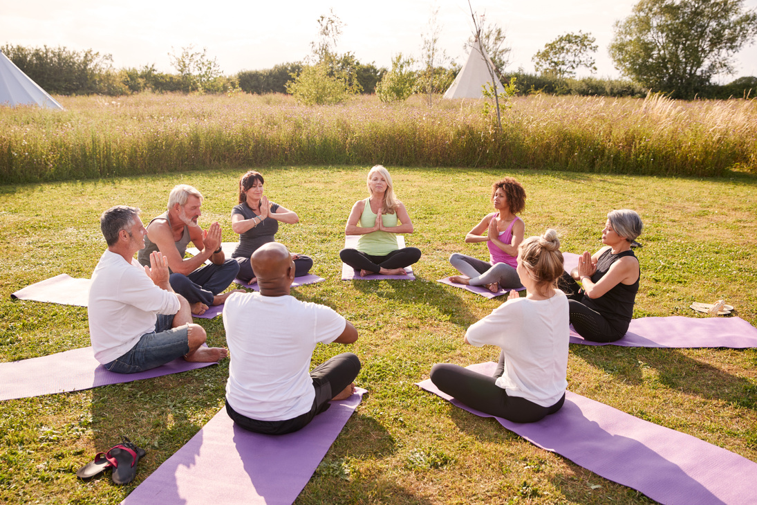 Group of Mature Men and Women in Class at Outdoor Yoga Retreat S